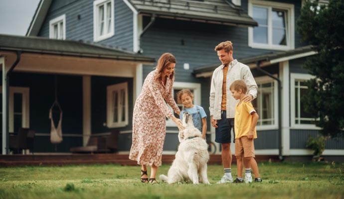 Happy family playing in front of their house