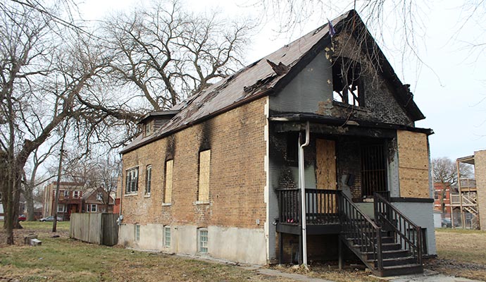 Boarded-up fire-damaged house