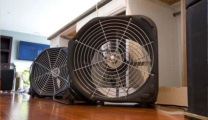 Commercial air mover fans drying kitchen hardwood floor