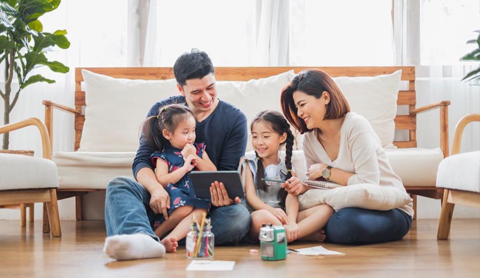 Family sitting on floor using tablet together