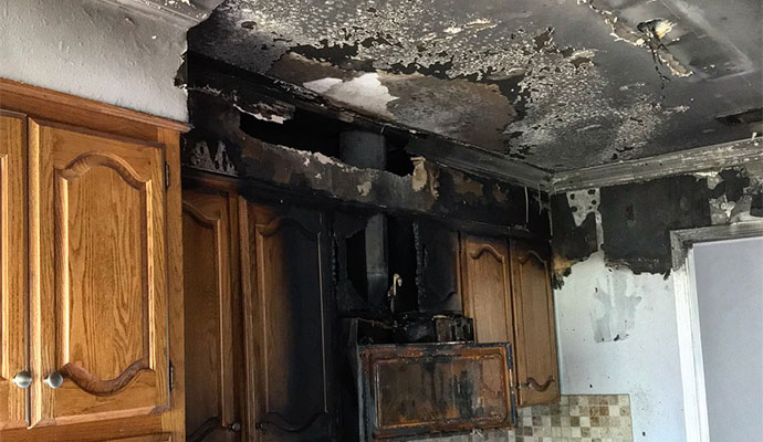 Fire and soot damaged kitchen wall and cabinets