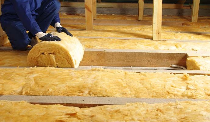 A professional of M&J Restoration installing new insulation