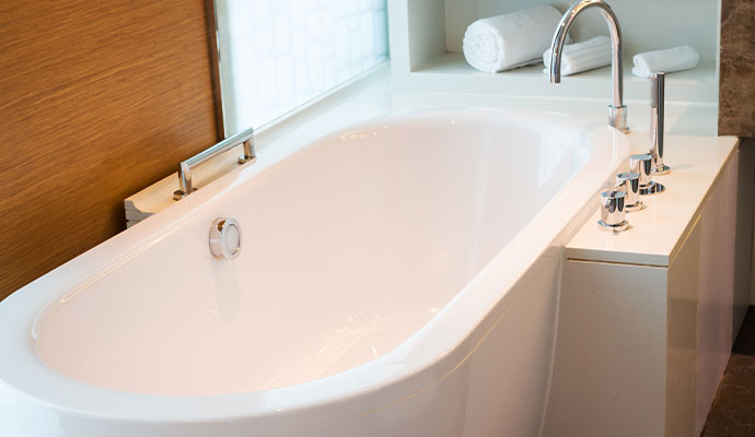 Clean modern white soaking bathtub in a residential bathroom