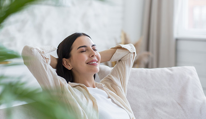 Smiling woman relaxing on sofa at home