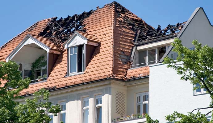 Fire damaged residential roof with charred rafters