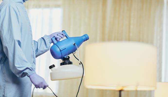 Technician holding fogger machine for smoke odor deodorization