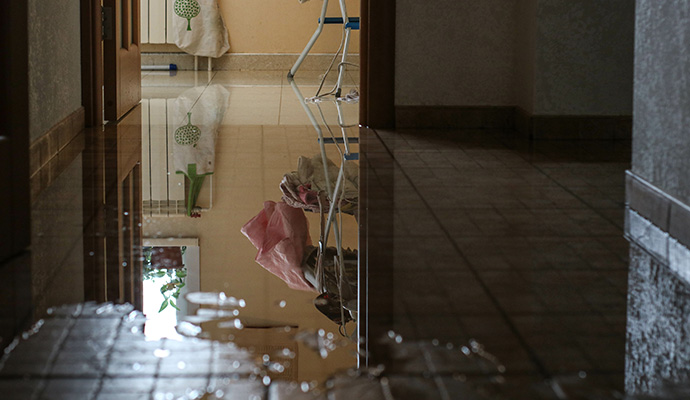 Standing water covering a tiled hallway floor