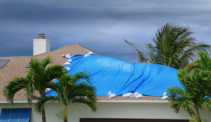 House roof covered by blue tarp