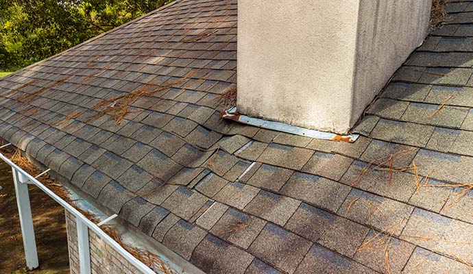 Damaged roof shingles and chimney flashing causing leak