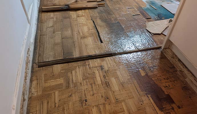 Water damaged and buckled wood parquet flooring