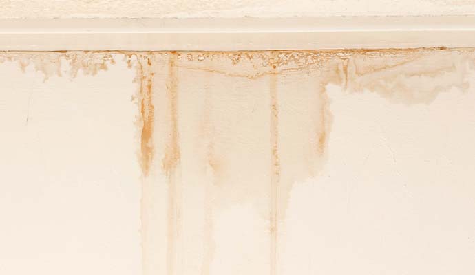 Water stains and streaks running down drywall wall