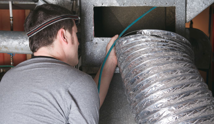 Technician cleaning HVAC duct system