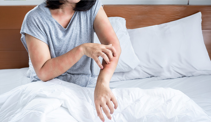 Woman experiencing skin irritation and allergy symptoms from damp indoor conditions